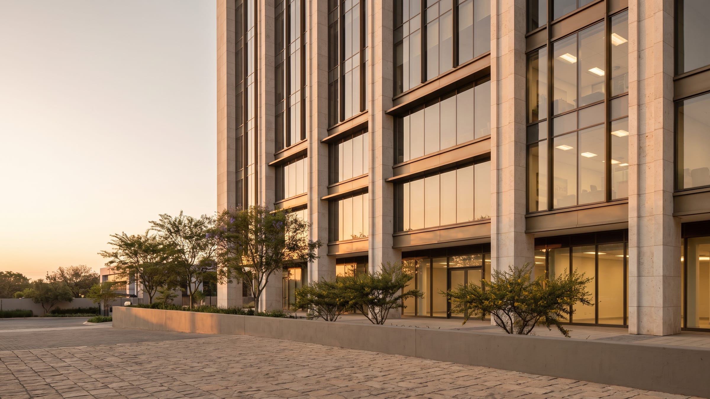Warm dusk light across the glazed facade of a commercial office building